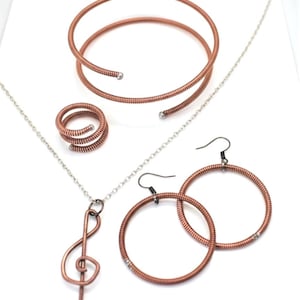 Sieradenset gerecyclede pianosnaar: solsleutelketting, armband, oorbellen