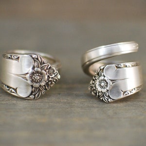 Op de afbeelding: Twee zilveren ringen gemaakt van vintage bestek met bloemmotieven. De ringen zijn beide open en verstelbaar.