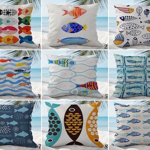 May include: A selection of decorative cushions with fish motifs. The cushions display colourful fish patterns in blues, oranges, greens, and yellows. Designs include rows of fish, individual fish, and abstract fish shapes.