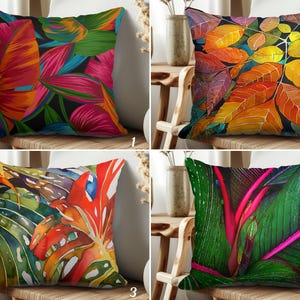 May include: Four decorative throw pillows with vibrant botanical designs. Each pillow features a different colorful leaf pattern, including tropical leaves and autumn foliage. The pillows are square and rest on wooden chairs.