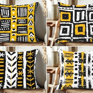 Puede incluir: Cuatro cojines decorativos con patrones geométricos en negro, blanco y amarillo. Cada cojín presenta un diseño único, que incluye rayas, cuadrados y formas abstractas. Los cojines son cuadrados y parecen estar hechos de tela.