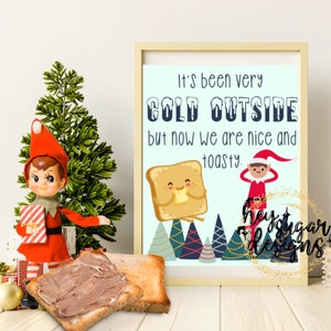May include: A printable Christmas card featuring a cartoon elf and a piece of toast with a smiling face. The text on the card reads "It's been very COLD OUTSIDE but now we are nice and toasty."