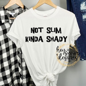 May include: White t-shirt with black text that reads "Not Slim Kinda Shady".