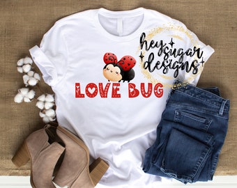 Könnte beinhalten: Weißes T-Shirt mit einer roten Marienkäfer-Grafik und dem Text "LOVE BUG" in roten Buchstaben mit weißen Herzen. Der Text "hey sugar designs" ist in Schwarz mit goldenem Glitzer.