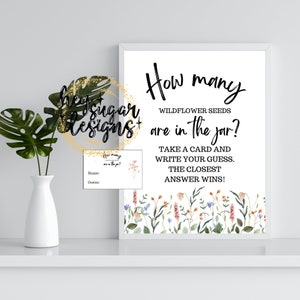 Pode incluir: Um cartaz branco com uma borda floral e o texto "Quantas sementes de flores silvestres estão no frasco?" Pegue um cartão e escreva seu palpite. A resposta mais próxima ganha!