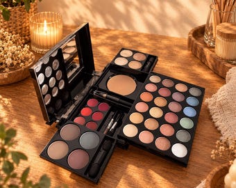 May include: A multi-tiered black makeup palette featuring a wide array of circular eyeshadows in neutral, metallic, and pastel tones, alongside pressed powders, vibrant red lip colors, and small applicator brushes housed within the folding case.