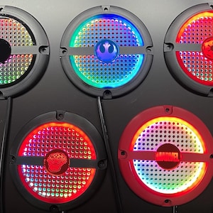 May include: Five circular LED lights with black surrounds, displaying vibrant light patterns. Some feature Star Wars and Marvel logos. Each light has a perforated centre and a power cable.