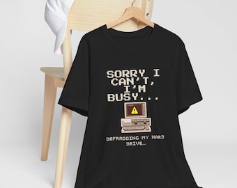 May include: Black t-shirt with a retro computer graphic and the text "Sorry I can't, I'm busy... Defragging my hard drive..."