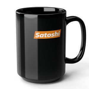 Op de afbeelding: Zwarte keramische mok met een wit "Satoshi" logo in een oranje rechthoek.