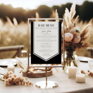 Può includere: Un cartello del menu del bar in bianco e nero con una cornice dorata. Il menu elenca drink signature, vino e champagne, cocktail classici, selezione di birre e il testo "Bar Menu".