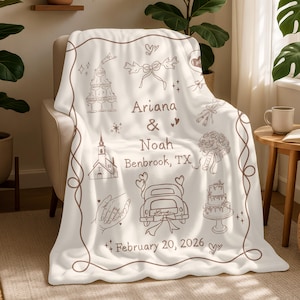 Puede incluir: Una manta color crema con ilustraciones en línea marrón de iconos relacionados con bodas, incluyendo una iglesia, un pastel y un coche. La manta presenta los nombres "Ariana & Noah" y la fecha "20 de febrero de 2026."