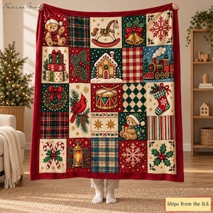 Op de afbeelding: Een grote rechthoekige plaid met een patchworkontwerp van kerstillustraties, waaronder een teddybeer, hobbelpaard, peperkoekhuisje, stoomtrein, kardinaalvogel, trommel, kerstsok, zuurstokken en een lantaarn op een rode rand.