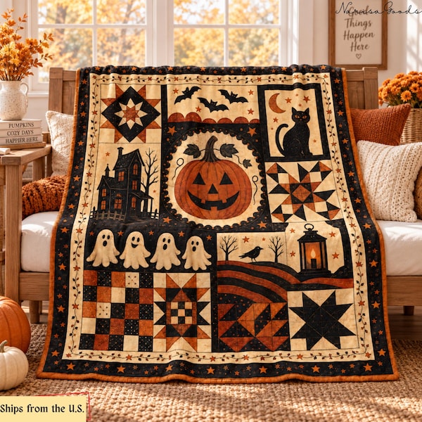 Op de afbeelding: Een quilt met Halloween-thema met een centrale oranje pompoen omringd door blokken met een zwarte kat, een spookhuis, geesten, vleermuizen, een kraai, een lantaarn en geometrische sterpatronen in een kleurenpalet van zwart, oranje en crème.