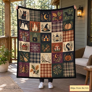 Puede incluir: Una manta rectangular con una cuadrícula de cuadrados que muestran motivos de otoño y Halloween, incluyendo un gato negro, fantasmas, velas, un sombrero de bruja, calabazas, una telaraña, una escoba, un búho y patrones de cuadros, bordeada con tela negra.