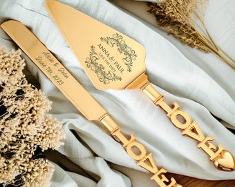 May include: Gold wedding cake server set with the words "LOVE" engraved on the handles. The server blades are engraved with the text "Anna & Paul Save the Date" and "Alicia & John June 7th, 2023".