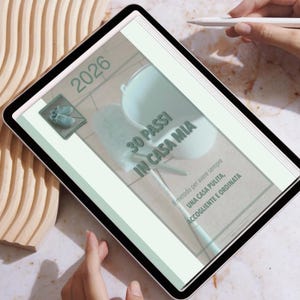 Può includere: Un tablet digitale che mostra una guida per la pulizia intitolata "30 PASSI IN CASA MIA" (30 passi a casa mia) per il 2026. L'immagine include un secchio, uno spolverino e testo in italiano, con un paio di scarpe.