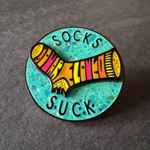 Emaille pin Socks Suck Spinner – grappig glitterontwerp