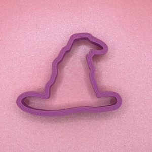 May include: A purple plastic cookie cutter shaped like a wizard's hat.