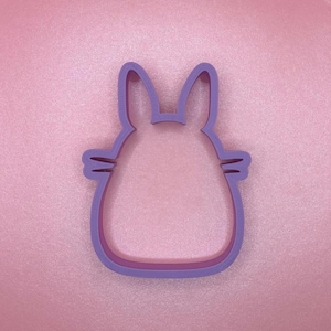 Pode incluir: Cortador de biscoitos de plástico roxo em forma de coelho de desenho animado com orelhas grandes e corpo redondo.