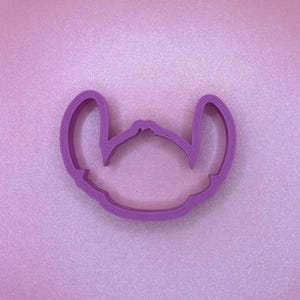 Peut inclure: Emporte-pièce en plastique violet en forme de Stitch de Lilo & Stitch.