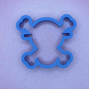 May include: A blue plastic cookie cutter shaped like a skull and crossbones.