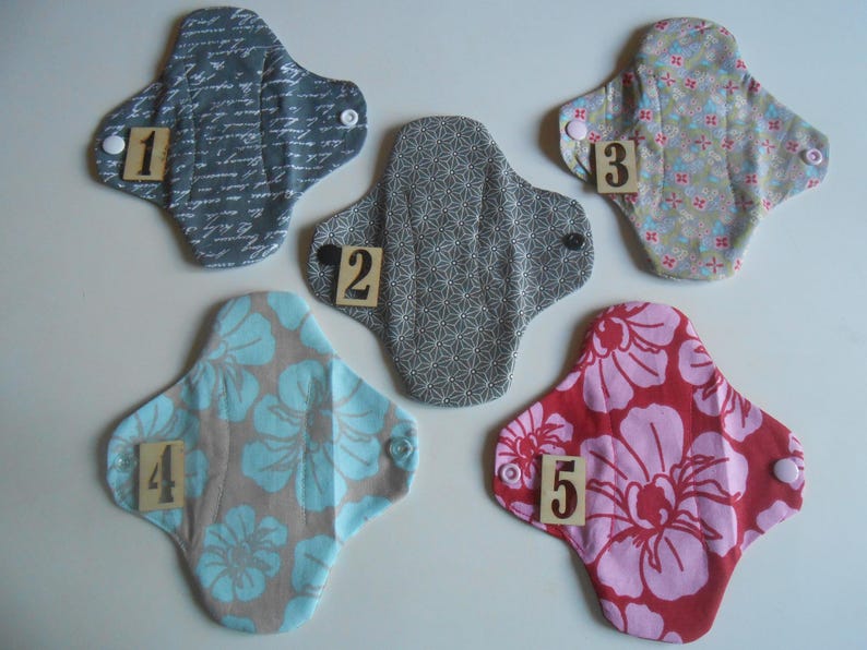 May include: Five reusable cloth pads in different patterns and colors. The pads are numbered 1 through 5.