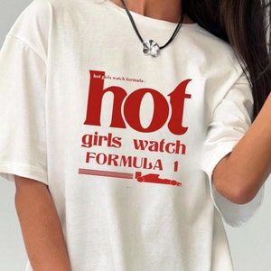 Peut inclure: T-shirt blanc avec un texte rouge qui dit "hot girls watch formula 1".