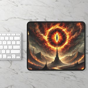 May include: A black and orange mousepad with a fiery eye and a tower in the background. The eye is surrounded by a ring of fire.