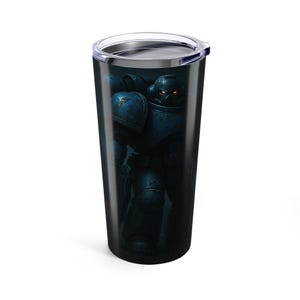 May include: A black travel tumbler featuring a detailed illustration of a blue armored figure with glowing red eyes. The design is set against a dark background, creating a dramatic effect. The tumbler has a silver lid.
