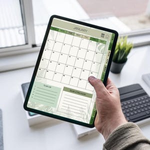 May include: A digital calendar displayed on a tablet, showing the month of January. The calendar has a green and white color scheme with a floral design. It includes a to-do list and a section for monthly goals.