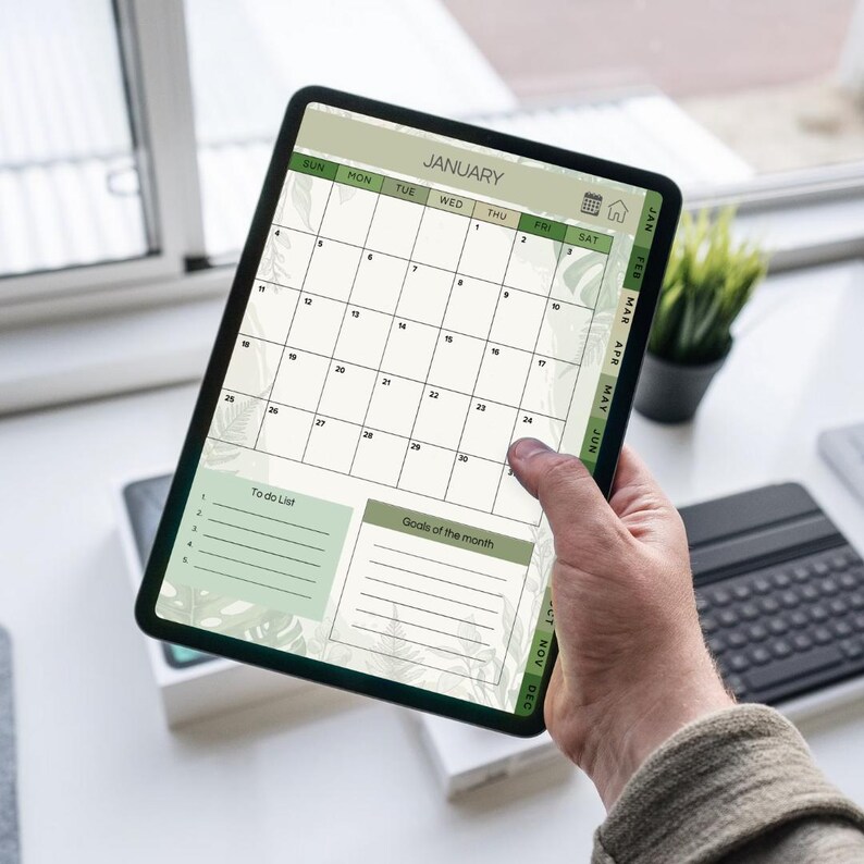 May include: A digital calendar displayed on a tablet, showing the month of January. The calendar has a green and white color scheme with a floral design. It includes a to-do list and a section for monthly goals.