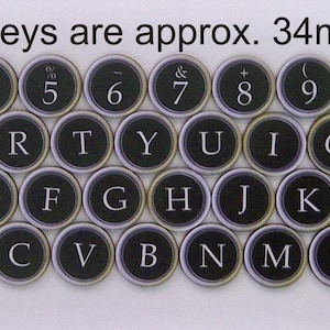 May include: Black and white typewriter keys with letters and numbers. All keys are approximately 34mm in diameter. The keys are arranged in a standard typewriter keyboard layout.