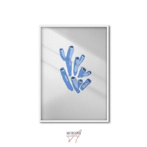 May include: A framed print featuring a watercolor illustration of blue coral against a white background. The coral is depicted with varying shades of blue, and the artwork is set within a white frame. The print is signed in the bottom right corner.