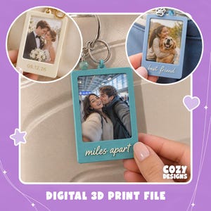 May include: Three rectangular photo frame keychains with metal rings. One is cream with the date 08.12.26, one is light blue with the text best friend, and one is teal with the text miles apart. These are 3D printed frames for photos.
