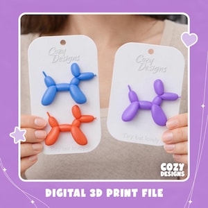 May include: Three balloon dog-shaped pins in blue, orange, and purple, attached to white display cards labelled Cozy Designs and Tiny but lovely. The pins feature a smooth, matte finish and are shaped like classic balloon animals with rounded limbs.