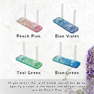 May include: Four acrylic display stands in peach pink, blue violet, teal green, and blue green. Each stand has a rectangular base and two vertical supports. Text on the image reads "Peach Pink", "Blue Violet", "Teal Green", and "Blue Green".