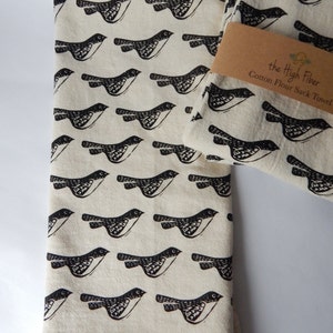 May include: Two white cotton flour sack towels with a black bird pattern and the text "the High Fiber Cotton Flour Sack Towel".