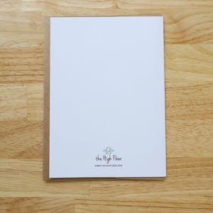 May include: A white card with a brown border, on a wooden surface. The card has the text "the High Fiber" and the website address www.thehighfiber.com.