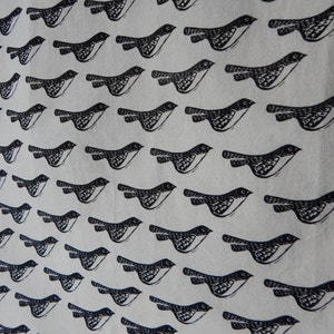 May include: A white fabric tote bag with a black and white repeating pattern of birds flying in a diagonal line. The birds are stylized and have a simple design.