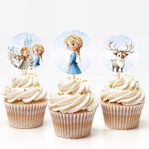 Puede incluir: Tres cupcakes con glaseado blanco y chispas doradas. Cada cupcake tiene un adorno redondo con personajes de la pel&iacute;cula animada Frozen. Los adornos incluyen a Elsa, Anna, Olaf y Sven.