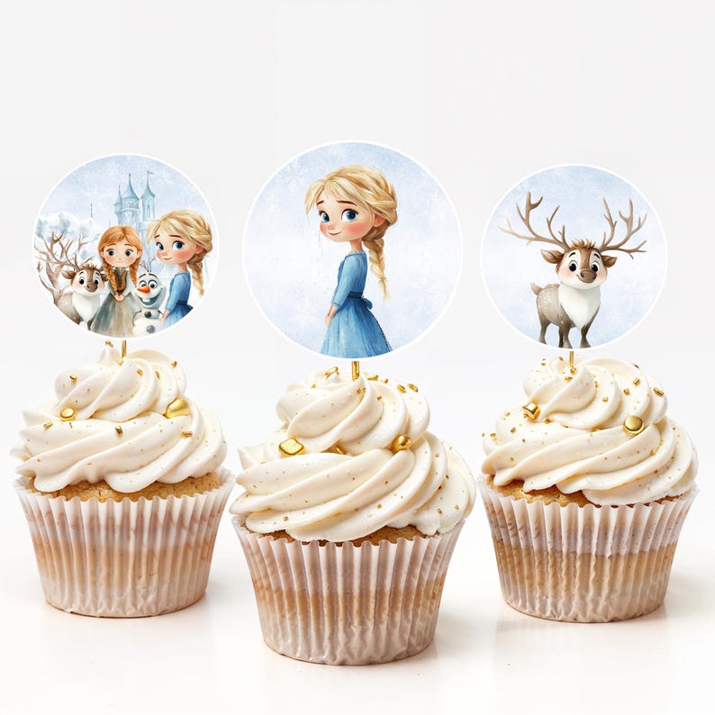 Puede incluir: Tres cupcakes con glaseado blanco y chispas doradas. Cada cupcake tiene un adorno redondo con personajes de la pel&iacute;cula animada Frozen. Los adornos incluyen a Elsa, Anna, Olaf y Sven.