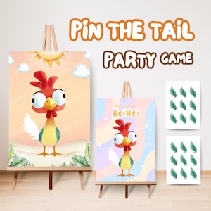 Puede incluir: Dos carteles de juego de fiesta sobre caballetes. Un cartel presenta un gallo de dibujos animados con cresta roja, pico amarillo y plumas blancas. El otro cartel tiene el texto "Pin the tail on HeiHei". Se incluyen recortes de hojas adicionales.
