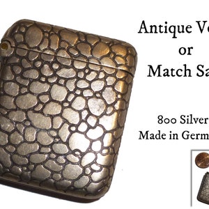May include: Antique silver match safe or vesta case with a textured, pebble-like design.  Made in Germany. 800 Silver.