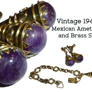 May include: A vintage 1940s set of amethyst and brass jewellery. The set includes a necklace, a pair of earrings, and a bracelet. The amethyst stones are a deep purple colour and are set in ornate brass settings. The necklace features a pendant with a large amethyst stone and a chain with a clasp. The earrings are drop earrings with amethyst stones and brass settings. The bracelet is a chain bracelet with a clasp.