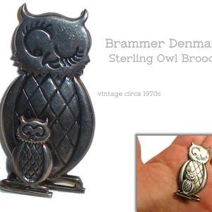 Pu&ograve; includere: Un broche a forma di gufo in argento con un gufo pi&ugrave; piccolo sul petto. Il broche &egrave; della marca Brammer Denmark ed &egrave; vintage, risalente agli anni '70.