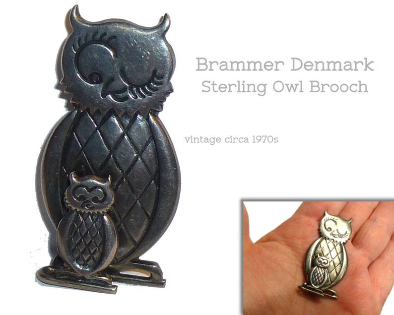 Pu&ograve; includere: Un broche a forma di gufo in argento con un gufo pi&ugrave; piccolo sul petto. Il broche &egrave; della marca Brammer Denmark ed &egrave; vintage, risalente agli anni '70.