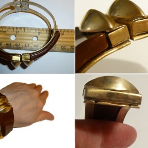May include: A brown bakelite bangle bracelet with gold-tone metal accents. The bracelet has a hinged closure and features a geometric design.
