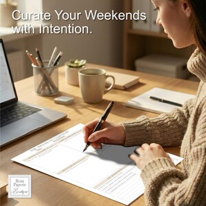 May include: A person writing on a "The Weekend Curator" planner with a pen. The planner is on a wooden desk with a laptop, coffee mug, and pencils. The text "Curate Your Weekends with Intention" is at the top. The Beau Paperie Boutique logo is in the bottom left.