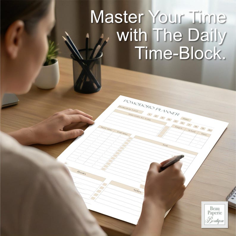 May include: A Pomodoro planner with the text "Master Your Time with The Daily Time-Block." The planner has sections for tasks, goals, and notes. The planner is on a wooden desk with a pen and pencils.