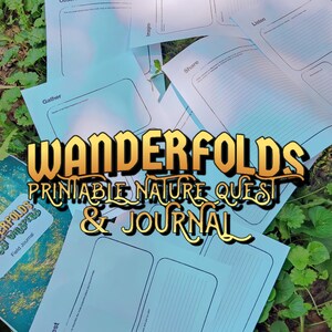 Pode incluir: Um conjunto de páginas de busca e diário da natureza imprimíveis em azul claro espalhadas sobre folhagem verde. O texto "Wanderfolds Printable Nature Quest & Journal" está em letras douradas. Um diário de campo também é visível.